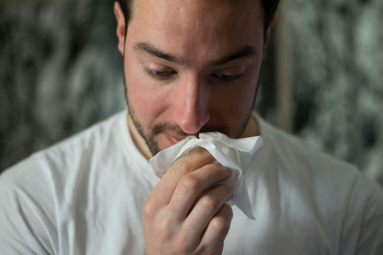Man wiping his nose with a tissue for allergy relief