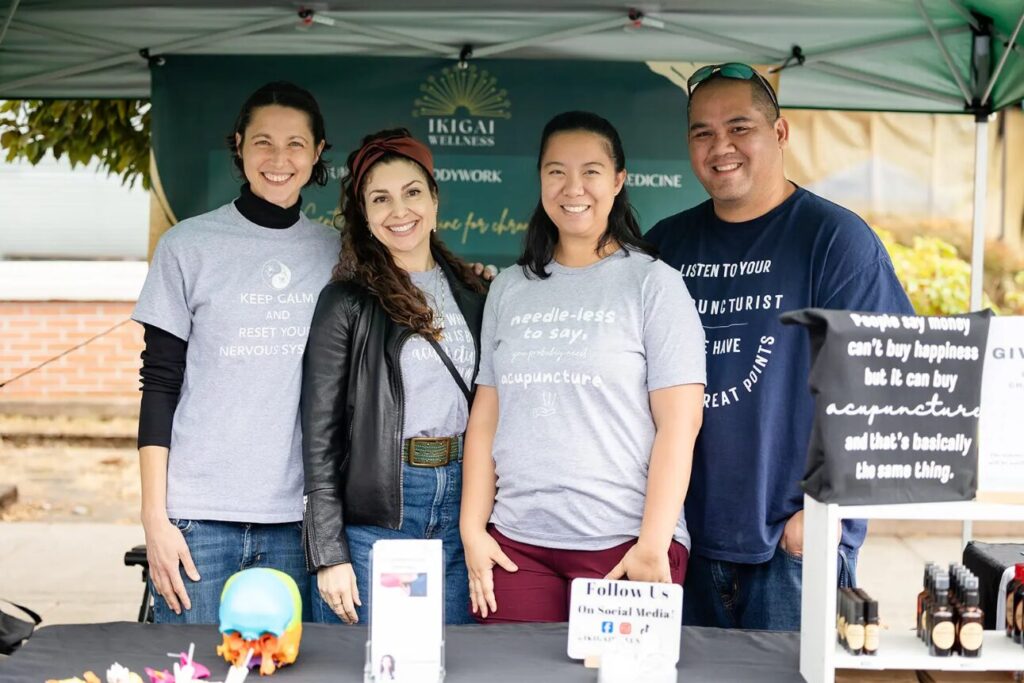 From left to right Erin, Monique, Amy and Michael stand behind their table at their booth