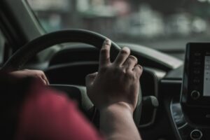 close up of a hand on a car steering wheel