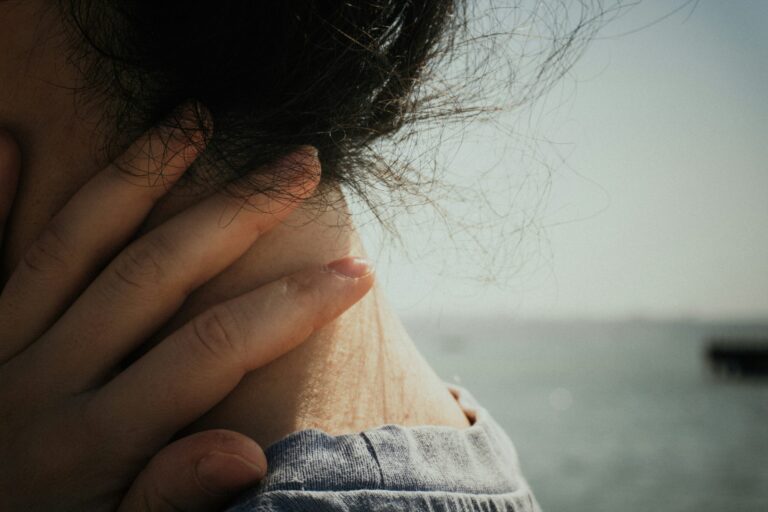 close up view of hand holding the back of the neck