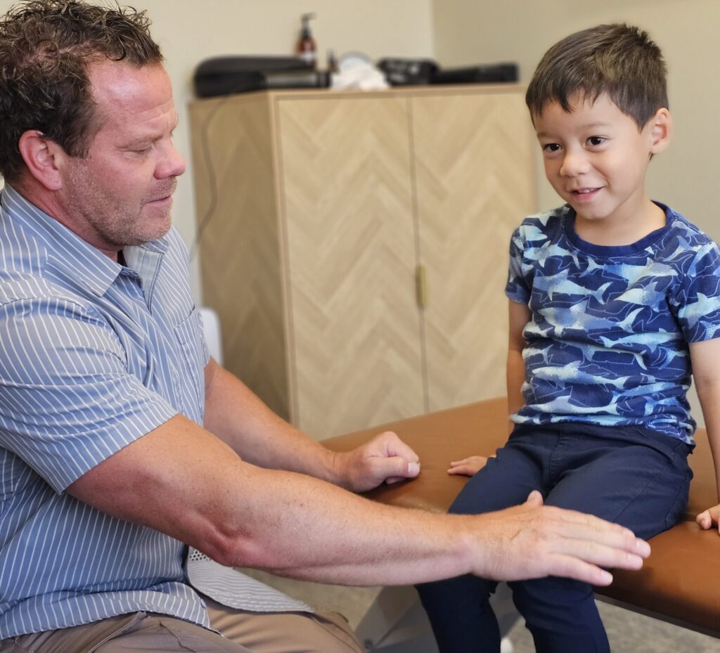 chiropractor testing leg strength with young child