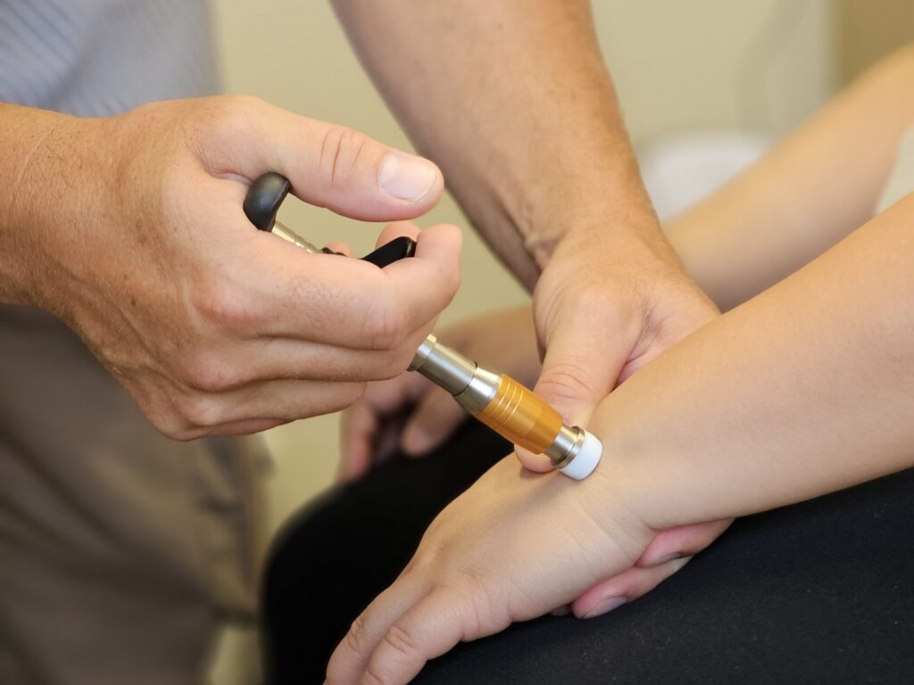 The Activator instrument being used on the wrist of a patient